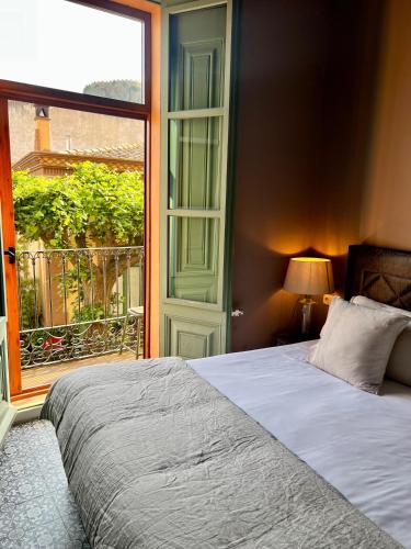 a bedroom with a bed and a large window at La Indiana de Begur, Petit Hotel Boutique in Begur