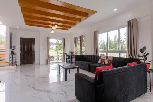 a living room with two couches and a piano at Cozy Crib Saratoga in Tagaytay Midlands with Breakfast in Tagaytay