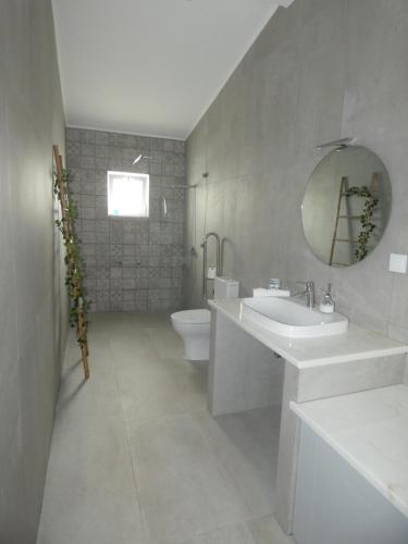 a bathroom with a sink and a toilet and a mirror at Quinta do Freixo in Elvas