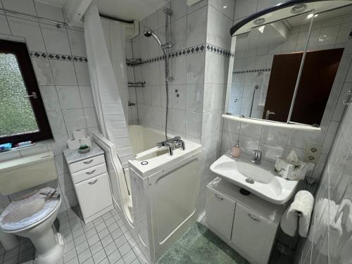Baño blanco con lavabo y aseo en Schönes, friedliches Zimmer, en Augsburg