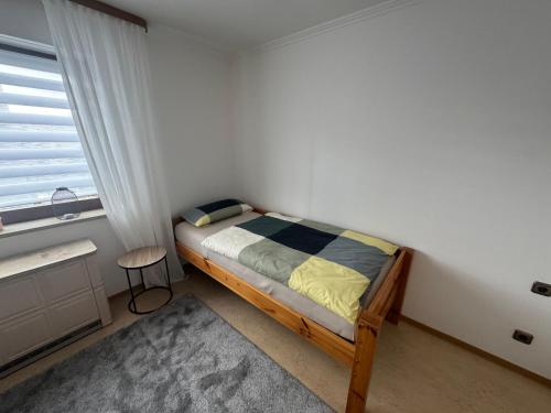 a small bedroom with a bed and a window at Schönes, friedliches Zimmer in Augsburg