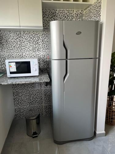 einen Kühlschrank aus Edelstahl in einer Küche mit einer Mikrowelle in der Unterkunft Departamento a minutos del centro in Posadas