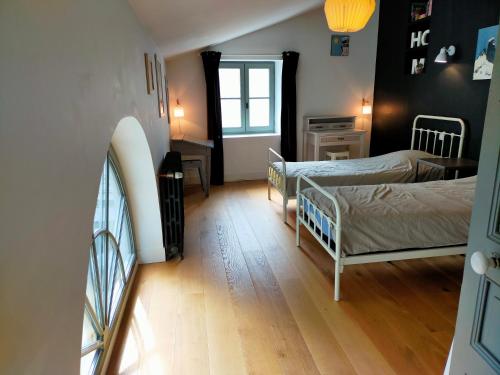 a small room with two beds and a window at La Suite 14 in Cholet