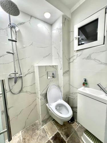 a white bathroom with a toilet and a sink at Titan Studio in Bucharest