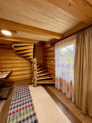 a room with a staircase in a log cabin at Садиба BETWEEN MOUNTAINS in Mizhhirya