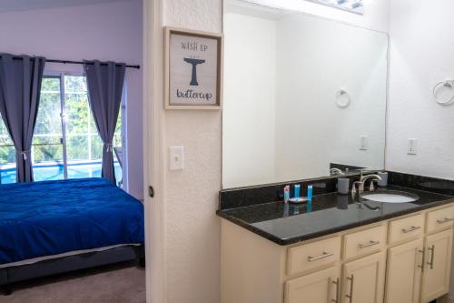 a bathroom with a sink and a mirror and a bed at Home in davenport Cheerful 4-bedroom with pool in Davenport