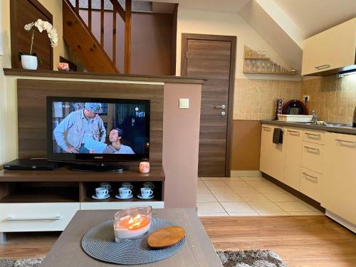 ein Wohnzimmer mit einem TV in der Küche in der Unterkunft Apartman TULANIE 58 Kamzik Donovaly 2 IZBOVY Mezonet Deluxe parkovanie v podzemnej garáži ZDARMA in Donovaly