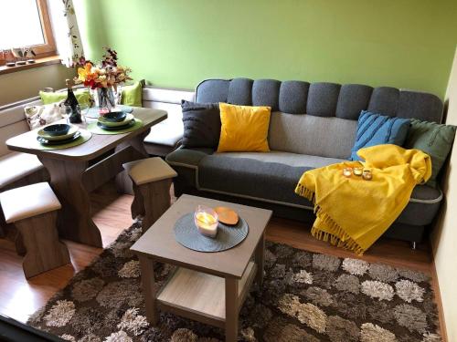 ein Wohnzimmer mit einer Couch und zwei Tischen in der Unterkunft Apartman TULANIE 58 Kamzik Donovaly 2 IZBOVY Mezonet Deluxe parkovanie v podzemnej garáži ZDARMA in Donovaly