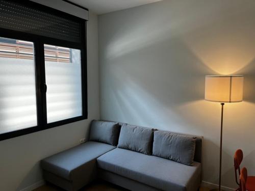 - un salon avec un canapé et une fenêtre dans l'établissement Exyca Plaza Castilla, à Madrid