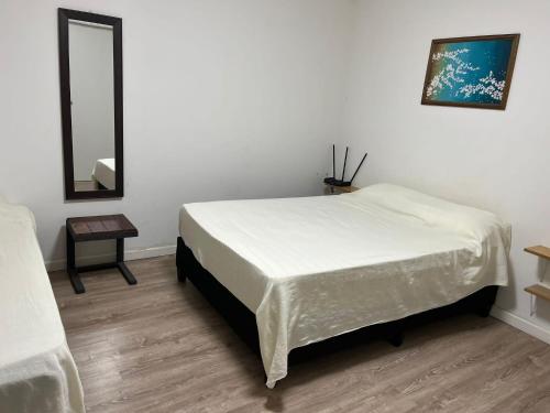 パイサンドゥーにあるRELAX IIの白いベッドルーム(ベッド1台、鏡付)