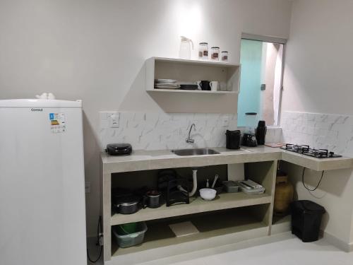une petite cuisine avec évier et comptoir dans l'établissement Casa de Mel, à Itacaré