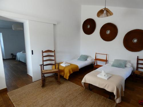 a living room with two beds and a chair at Quinta do Freixo in Elvas