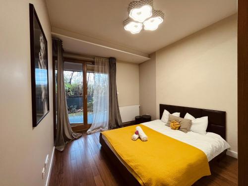 a bedroom with a large bed with a yellow blanket at Apartament Mecenasa in Krakow