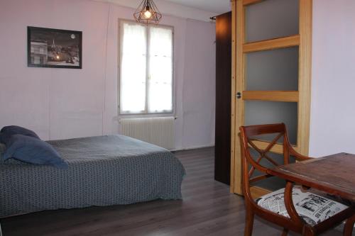 une chambre avec un lit, une table et une fenêtre dans l'établissement BEGUINES, à Chartres