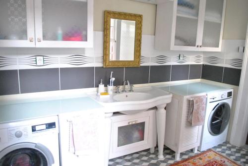 a bathroom with a sink and a washer and dryer at Maris , Greek House @ City Center ALSANCAK in Konak