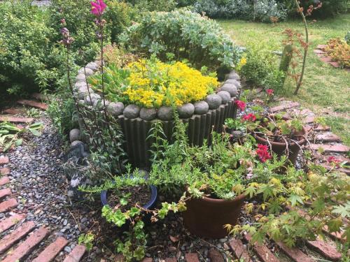 a flower garden with a large stone flower pot at Loft del Rio in Cajon del Maipo