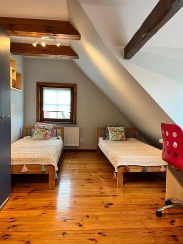 Duas camas num quarto com pisos em madeira em Chata Sikorki 