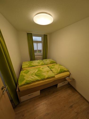 Habitación pequeña con cama y ventana en Ferienwohnung 1 en Schlettau