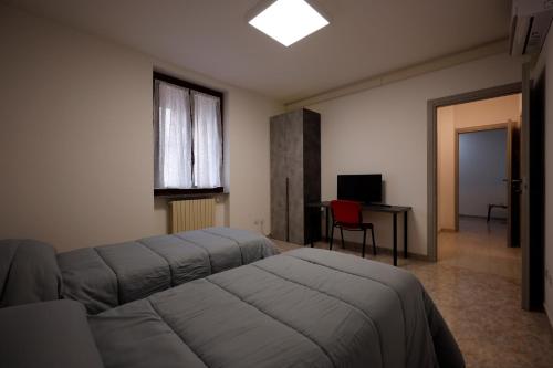a bedroom with a bed and a desk and a window at Placido's B&B in Rho