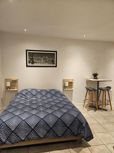 a bedroom with a bed and a table with stools at Cabanon Mairyon in Mairy-sur-Marne