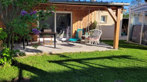 a patio with a table and chairs in a yard at Cabanon Mairyon in Mairy-sur-Marne