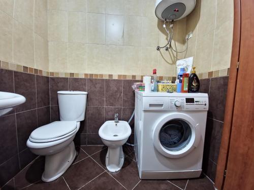 a bathroom with a toilet and a washing machine at Siar Apartment in Tirana