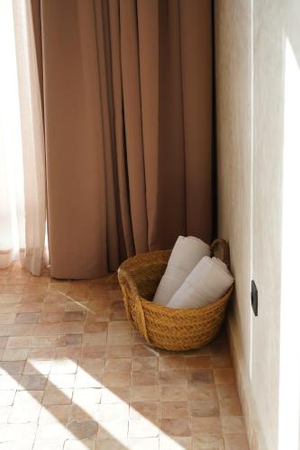 a basket chair sitting on the floor in a room at Loued Surf Lodge in Imsouane