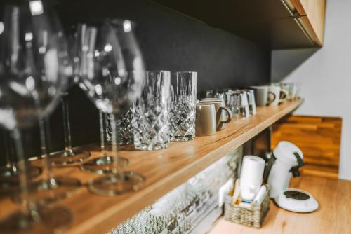 a row of wine glasses sitting on a wooden shelf at Stadthaus mitten in der Altstadt in Landshut