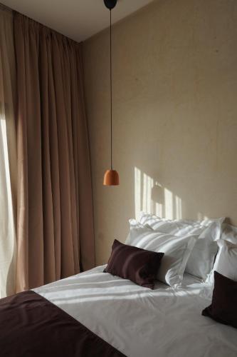 a bedroom with a bed with white sheets and pillows at Loued Surf Lodge in Imsouane