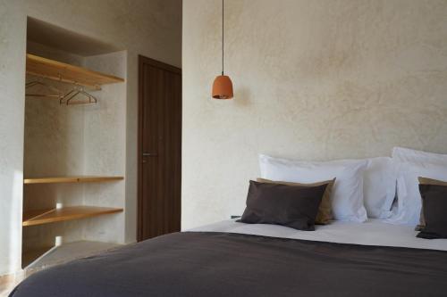 Schlafzimmer mit einem Bett mit weißer Bettwäsche und Kissen in der Unterkunft L'Oued the lodge in Imsouane