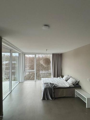 Dormitorio blanco con cama y ventana grande en Platinum VIP - Aurora luxury house en Tromsø