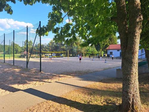 a park with people playing volley ball on a volleyball court at Przytulne mieszkanie w centrum Gołdap in Gołdap