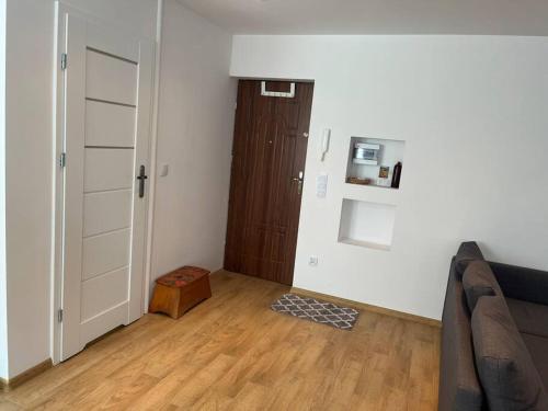 un soggiorno con divano e porta in legno di Przytulne mieszkanie w centrum Gołdap a Gołdap