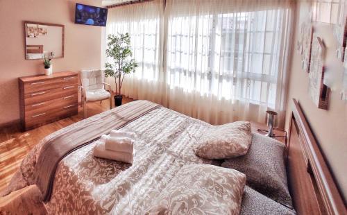 Apartamento con wifi en casco histórico Betanzos في بيتانزوس: غرفة نوم بسرير وخزانة ونافذة