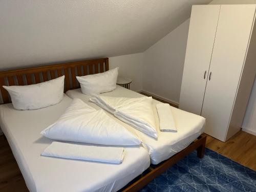a bed with white sheets and two towels on it at Ferienwohnung Alkapa in Hilzingen