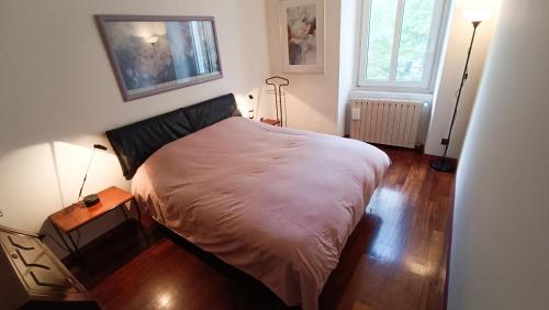 - une chambre avec un lit dans un dortoir doté de parquet dans l'établissement Casa Julí: 70mq-Centro-Trieste, à Trieste