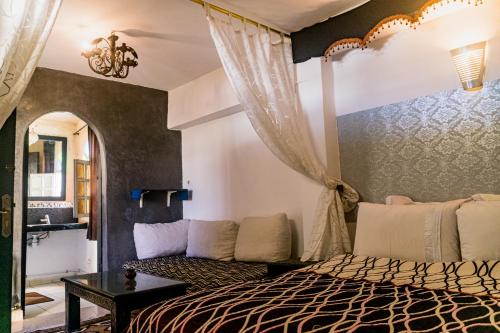 una camera con letto e divano di Essaouira Youth Hostel & Social Travel a Essaouira