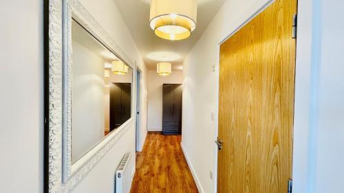 a hallway with a mirror and a wooden door at Urban Gem Apartment- Free parking in Enfield