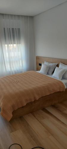 uma cama grande num quarto com piso em madeira em SIA Studio em Oradea