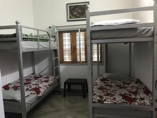 a room with two bunk beds and a window at 9Backpackers Dehradun in Dehradun