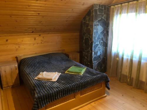 ein Schlafzimmer mit einem Bett in einem Blockhaus in der Unterkunft Карпатський Затишок in Huta