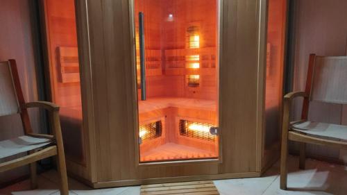 a glass door of a shower with two chairs at Quinta das Cantigas by Book YourHoliday PT in Aljubarrota