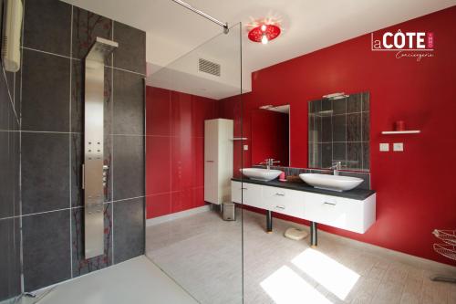 łazienka z 2 umywalkami i czerwoną ścianą w obiekcie CAP MARINE - 4 COUCHAGES w mieście Carry-le-Rouet