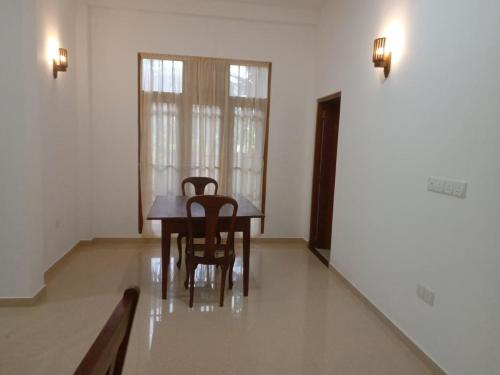馬特勒的住宿－Coconut Villa Madiha，一间带木桌和椅子的用餐室