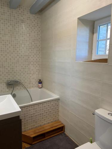 ein Bad mit einer Badewanne und einem WC in der Unterkunft Maison de campagne - La Guenellière - Maigné - Sarthe in Maigné