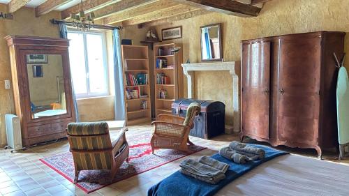 ein Wohnzimmer mit Möbeln und einem Kamin in der Unterkunft Maison de campagne - La Guenellière - Maigné - Sarthe in Maigné