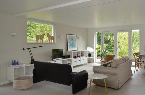a living room with a couch and a chair at Vakantiehuis Leukderhuisje Geulle Meerssen in Guelle