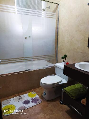 ein Bad mit einer Dusche, einem WC und einem Waschbecken in der Unterkunft SUITES NOA QUITO, LA CAROLINA.- in Quito
