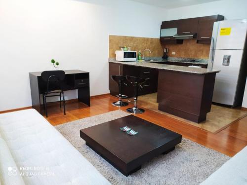 ein Wohnzimmer mit einer Küche mit einer Theke in der Unterkunft SUITES NOA QUITO, LA CAROLINA.- in Quito