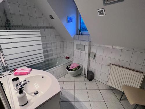 uma casa de banho com um lavatório e uma banheira em Ferienhaus am Mühlgraben em Thale